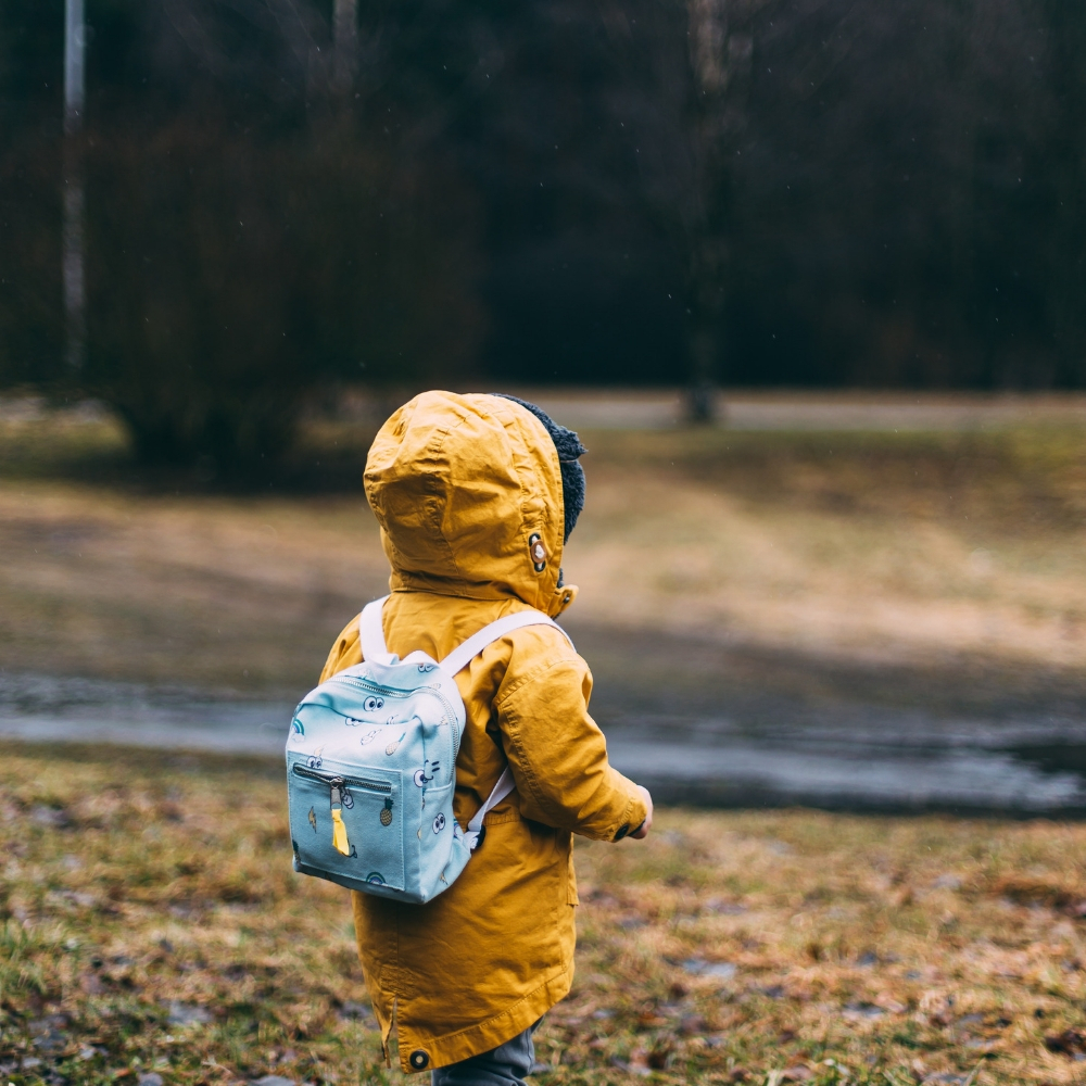 a toddler carrying backpack